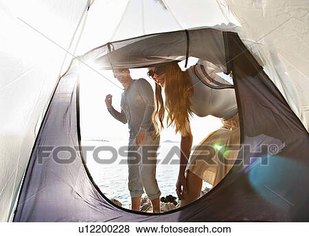 Stock Photo - Couple with tent by sea. Fotosearch