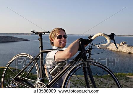 Cyclist looking out at sea View Large Photo Image Stock Photo - Cyclist looking out at sea. Fotosearch