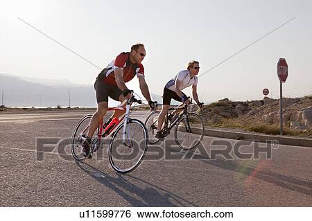 Cyclists on country road by sea View Large Photo Image Stock Photograph - Cyclists on country road by sea. Fotosearch