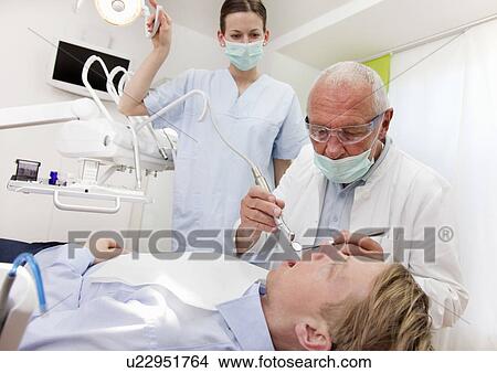 Picture - Dentist with patient in surgery. Fotosearch