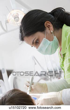 Dentist with patient in surgery View Large Photo Image Stock Image - Dentist with patient in surgery. Fotosearch