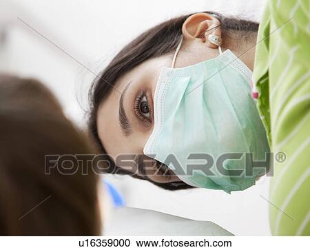 Stock Image - Dentist with patient in surgery. Fotosearch