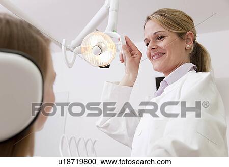 Dentist with patient in surgery View Large Photo Image Stock Image - Dentist with patient in surgery. Fotosearch