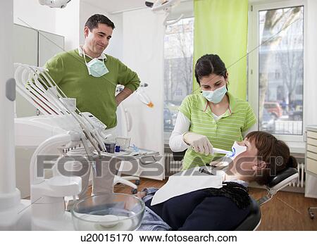 Dentist with patient in surgery View Large Photo Image Stock Image - Dentist with patient in surgery. Fotosearch
