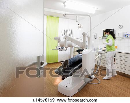 Dentist with patient in surgery View Large Photo Image Stock Photo - Dentist with patient in surgery. Fotosearch