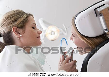 Stock Photo - Dentist with patient in surgery. Fotosearch