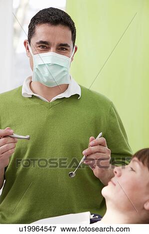 Stock Photo - Dentist with patient in surgery. Fotosearch