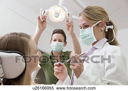 Dentist with patient in surgery View Large Photo Image Stock Photography - Dentist with patient in surgery. Fotosearch