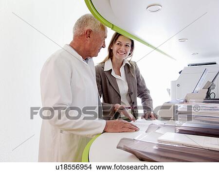 Picture - Doctor and businesswoman in surgery. Fotosearch
