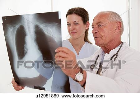 Stock Photo - Doctor and nurse looking at x-ray. Fotosearch