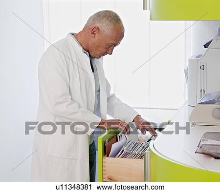 Stock Image - Doctor browsing patient files. Fotosearch