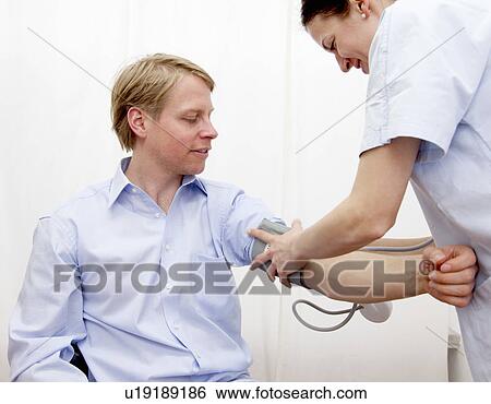 Stock Photograph - Doctor patient taking blood pressure. Fotosearch