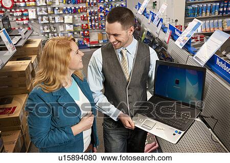 Stock Image - Employee presenting new notebook model. Fotosearch