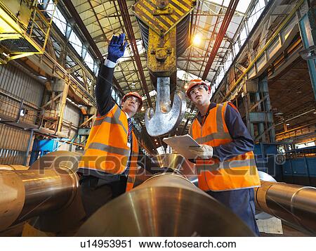Stock Image - Engineer & Apprentice With Steel Rollers. Fotosearch
