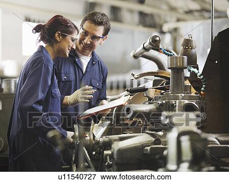 Stock Photo - Engineer Teaching Female Apprentice. Fotosearch