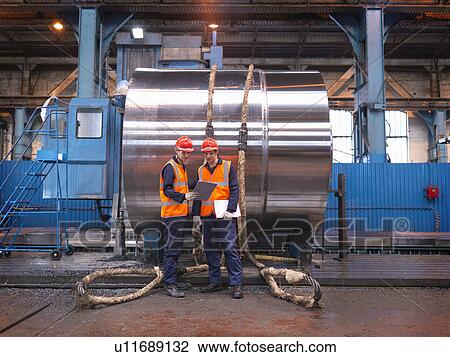 Stock Image - Engineers In Factory With Finished Steel. Fotosearch