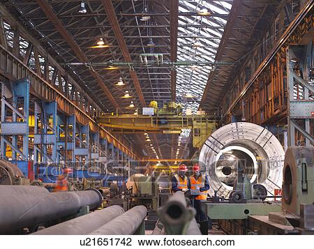 Stock Image - Engineers In Steel Factory With Lathe. Fotosearch