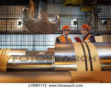 Stock Image - Engineers Inspecting Steel Rollers. Fotosearch