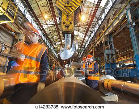 Stock Photography - Engineers With Finished Steel Rollers. Fotosearch