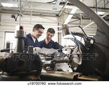 Stock Image - Experienced Engineer Teaching Apprentice. Fotosearch