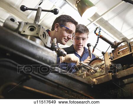 Stock Photo - Experienced Engineer Teaching Apprentice. Fotosearch