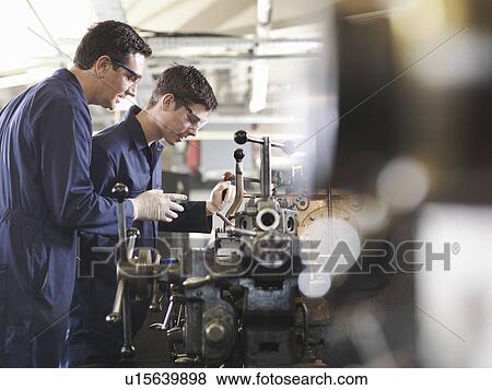 Stock Photo - Experienced Engineer Teaching Apprentice. Fotosearch