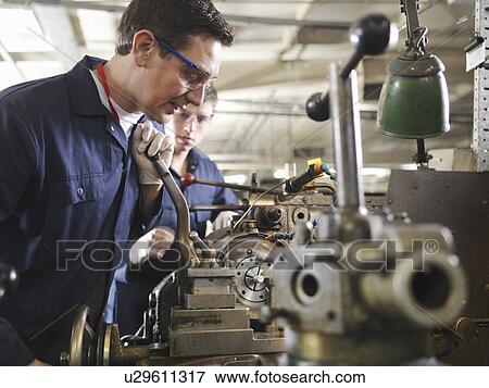 Stock Photo - Experienced Engineer Teaching Apprentice. Fotosearch