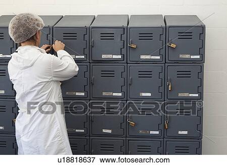 Factory worker opening locker View Large Photo Image Stock Photo - Factory worker opening locker. Fotosearch