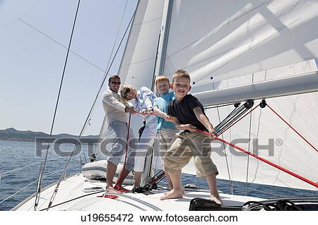Stock Image - Family pulling rope on yacht. Fotosearch