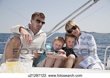 Stock Image - Family sitting together on yacht. Fotosearch
