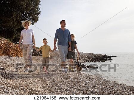 Family with dog walking at the beach View Large Photo Image Stock Photo - Family with dog walking at the beach. Fotosearch
