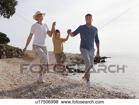 Family with jumping son at the beach View Large Photo Image Stock Photo - Family with jumping son at the beach. Fotosearch