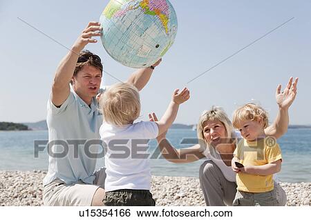 Family with twins at beach playing ball View Large Photo Image Stock Photograph - Family with twins at beach playing ball. Fotosearch