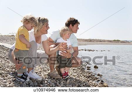 Stock Photograph - Family with twins at the beach. Fotosearch