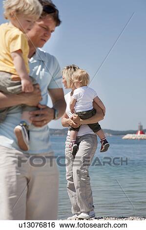 Family with twins at the beach View Large Photo Image Stock Photograph - Family with twins at the beach. Fotosearch