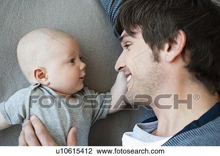 Stock Image - Father and baby looking to each other. Fotosearch
