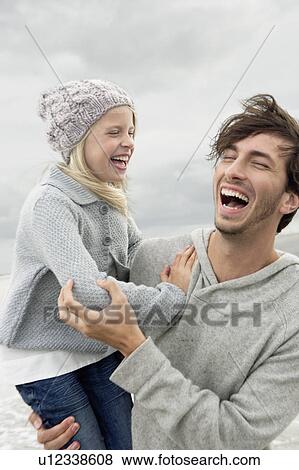 Father and daughter laughing on beach View Large Photo Image Stock Photo - Father and daughter laughing on beach. Fotosearch