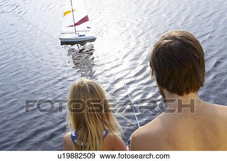 Stock Photo - Father and daughter with rc boat on lake. Fotosearch