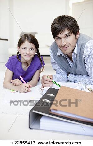 Stock Image - Father and girl doing paperwork. Fotosearch