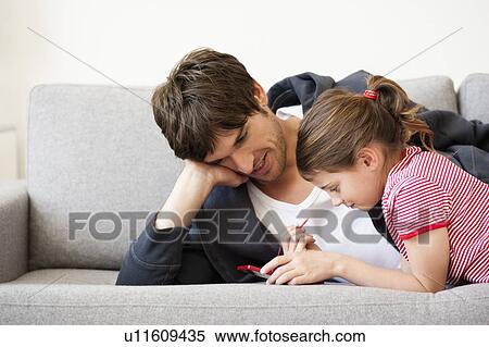 Stock Photography - Father and girl playing video game. Fotosearch