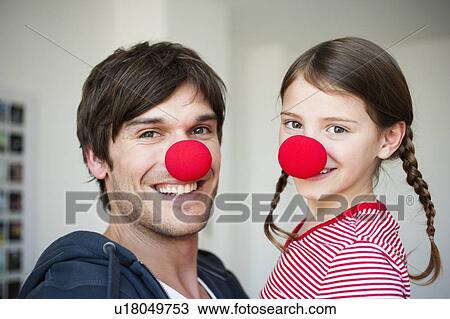 Stock Image - Father and girl wearing red noses. Fotosearch