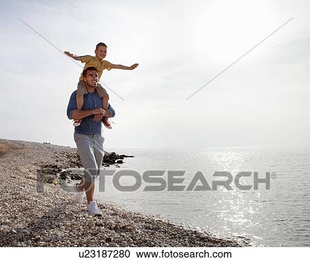 Father and son at the beach View Large Photo Image Stock Image - Father and son at the beach. Fotosearch