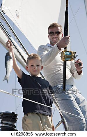 Stock Photograph - Father and son fishing on yacht. Fotosearch