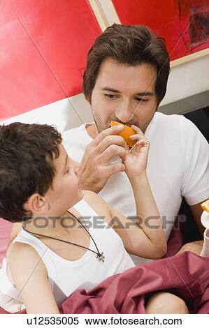 Stock Photography - Father and son having breakfast in bed. Fotosearch