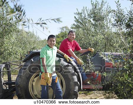 Stock Photograph - Father and son posing with tractor. Fotosearch