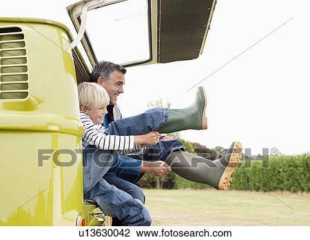 Father and son putting on boots View Large Photo Image Stock Image - Father and son putting on boots. Fotosearch