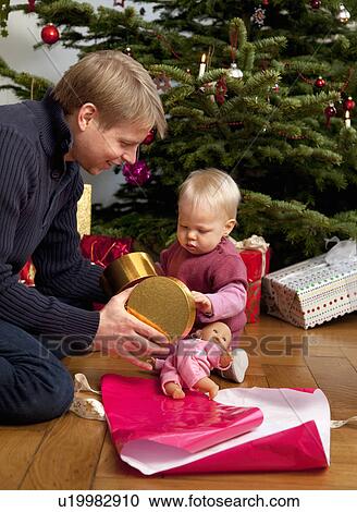 Stock Image - father, baby opening christmas present. Fotosearch