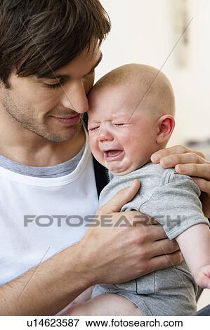 Stock Photo - Father holding crying baby. Fotosearch