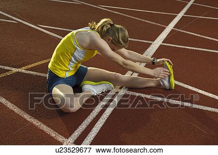 Stock Photo - female athlete stretching leg muscles. Fotosearch