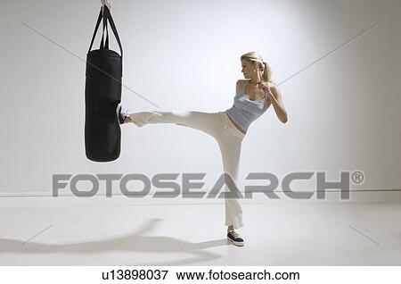 Female kicking punchbag View Large Photo Image Stock Photo - Female kicking punchbag. Fotosearch